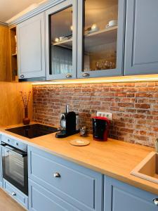 uma cozinha com armários brancos e uma bancada em Brand new, feel at home residence em Timisoara