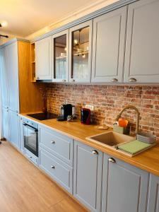 a kitchen with white cabinets and a sink at Brand new, feel at home residence in Timişoara