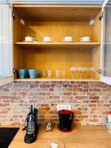 uma cozinha com uma parede de tijolos e prateleiras de madeira em Brand new, feel at home residence em Timisoara