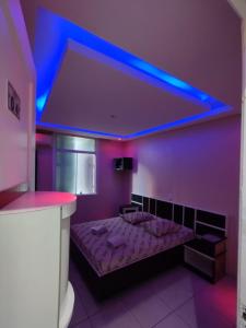 Habitación púrpura con cama con luz azul en Hotel Maraja 9 de julho, en São Paulo