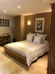 a bedroom with a large bed with white sheets and pillows at Chambres d'Hôtes La Chrysalide in Loriol-du-Comtat