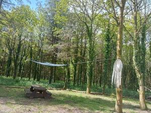 a hammock hanging from a tree next to a picnic table at tente nature in Plouray
