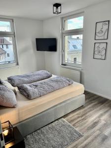a bedroom with two beds and a flat screen tv at Penthouse im Zentrum von Bregenz in Bregenz