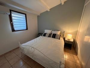 a bedroom with a white bed and a window at La Brise Marine in Cogolin