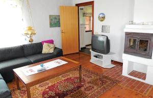 a living room with a couch and a tv at Nice Home In Simrishamn With Kitchen in Simrishamn