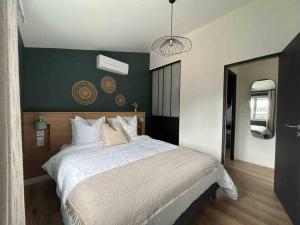 Un dormitorio con una cama grande y una pared verde. en T2 chic, calme proche Hopital, en La Tronche