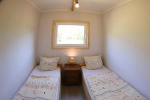 ein kleines Zimmer mit zwei Betten und einem Fenster in der Unterkunft Gwda24 in Stare Wierzchowo