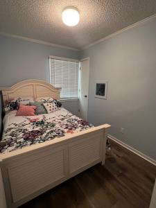 Schlafzimmer mit einem großen Bett mit einem Kopfteil aus Holz in der Unterkunft C Level Condo in Myrtle Beach
