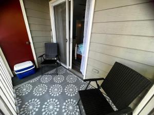 un porche con 2 sillas y un suelo con raquetas de nieve en C Level Condo, en Myrtle Beach