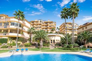 ein Resort mit einem Pool und Palmen in der Unterkunft Great Duplex Amazing sea views in Sitio de Calahonda