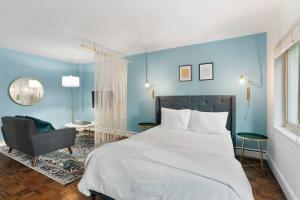a bedroom with a large bed and a chair at Studio in the Heart of Seattle - Fast Wi-Fi & AC in Seattle