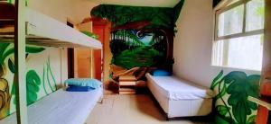 a room with two bunk beds and a painting on the wall at Beach House Ilha da Gigóia in Rio de Janeiro
