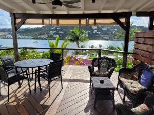 a porch with a table and chairs and a view of the water at Les Balcons d'Oyster Pond in Saint Martin