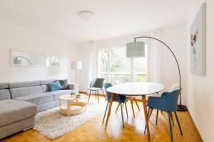 a living room with a couch and a table and chairs at Apartment of 52 sqm with free parking in Lausanne