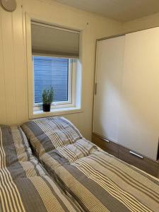 a bedroom with a large bed and a window at Ny rorbu ved sjøen, sentralt på Sunnmøre in Ålesund