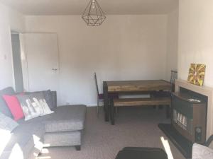uma sala de estar com um sofá e uma mesa em Entire 2 bed apartment - Up to 4 guest - 10 min from station and town centre em Wokingham