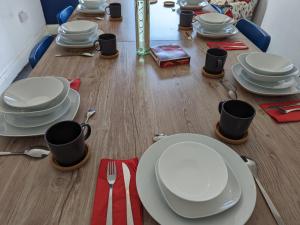 a table with white plates and utensils on it at Contractor HQ Spacious & Central 4 Bed Home in Newcastle upon Tyne