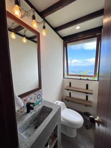 ein Badezimmer mit einem Waschbecken, einem WC und einem Spiegel in der Unterkunft El Filito in San JosÃ©