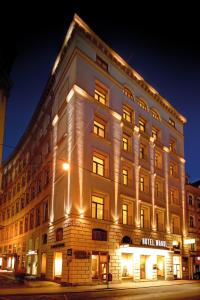 Un grand bâtiment blanc avec des lumières sur lui dans l'établissement Hotel Wandl, à Vienne