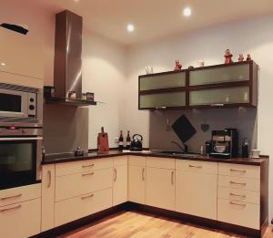 a kitchen with white cabinets and stainless steel appliances at Ferienwohnung Aroma Moselblick in Burgen