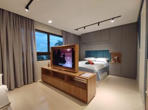 1 dormitorio con TV y 1 cama. en Rio Park Ave, Studio 9 - By TRH Invest, en Recife