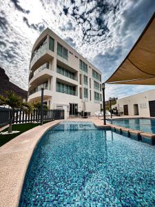 a large swimming pool in front of a building at Suites Rubí - Las Mejores vistas de San Carlos in San Carlos