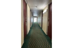a corridor of an office building with a long hallway at Kampus Inn by OYO Gainesville - University Area in Gainesville