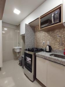 y cocina con fogones y microondas. en Rio Park Ave, Studio 9 - By TRH Invest, en Recife