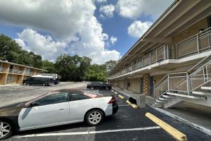 een witte auto geparkeerd voor een gebouw bij Kampus Inn by OYO Gainesville - University Area in Gainesville
