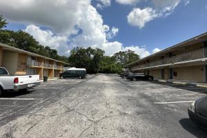een lege parkeerplaats met auto's naast een gebouw bij Kampus Inn by OYO Gainesville - University Area in Gainesville
