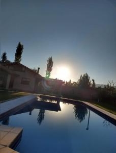 un reflejo del sol en una piscina de agua en Chacras Village en Luján de Cuyo