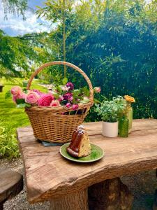 uma mesa de piquenique com um cesto de flores e um pedaço de pão em GSand Le Clos du May em Le Poinçonnet