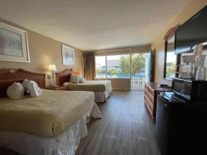 um quarto de hotel com duas camas e uma varanda em Polynesian Oceanfront Hotel em Myrtle Beach