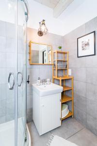 a bathroom with a sink and a shower and a mirror at DOMEK LUKSUSOWY KASZUBSKA OSTOJA in Barkocin