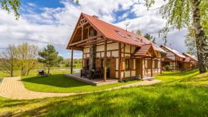 uma casa no meio de um campo verde em DOMEK LUKSUSOWY KASZUBSKA OSTOJA em Barkocin