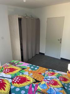 ein Schlafzimmer mit einem Bett mit einer bunten Decke in der Unterkunft Kazabasté, escapade spa et jardin privatif in Basse-Terre