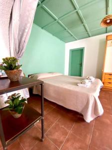 a bedroom with a bed and a table with plants at CasaMoltoCarina Cottage Garden in Minturno