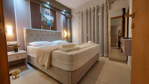 a bedroom with a large bed and a bathroom at Modern Apartment Kallithea 2 in Kallithea Halkidikis