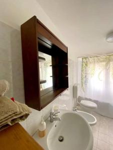 uma casa de banho com um lavatório e um WC em CasaMoltoCarina Cottage Garden em Minturno