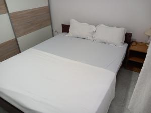 two beds in a room with white sheets and pillows at TOMI Apartment in Ulcinj