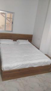 - un lit avec des draps blancs et une fenêtre dans une chambre dans l'établissement OYO Flagship Hotel The Cloud, à Jāmul