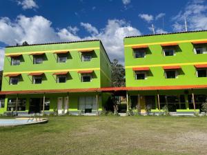 a green building next to a yellow building at Hotel COMTUCAR in Carhuaz