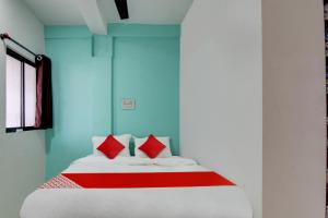 um quarto com uma cama grande e almofadas vermelhas em OYO Flagship Kings Hotel em Nagpur