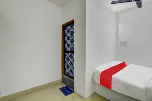 a white room with a bed and a window at OYO Flagship Kings Hotel in Nagpur