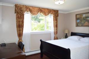 - une chambre avec un grand lit et une fenêtre dans l'établissement Jane's private rooms with shared washroom, à Surrey