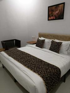een groot bed met een luipaardprint deken en kussens bij SPOT ON 81072 The Golden Key in Rāipur