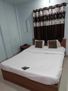 een slaapkamer met een groot wit bed en een gordijn bij SPOT ON 81072 The Golden Key in Rāipur