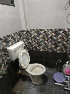 een badkamer met een wit toilet in een kamer bij SPOT ON 81072 The Golden Key in Rāipur