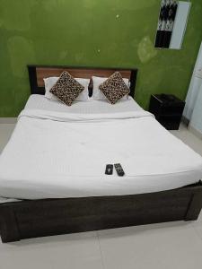 een bed in een groene kamer met een wit matras bij SPOT ON 81072 The Golden Key in Rāipur