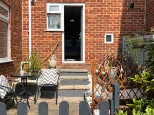 a brick house with a patio with a table and chairs at Glastonbury Hideaway in Glastonbury